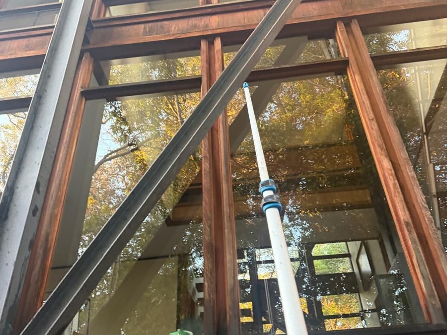 Cleaner squeegeeing a large exterior window (900×700)